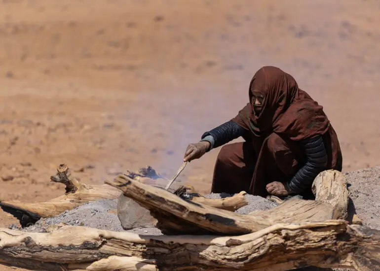 A nomadic woman tending a fire in the Erg Chigaga Desert