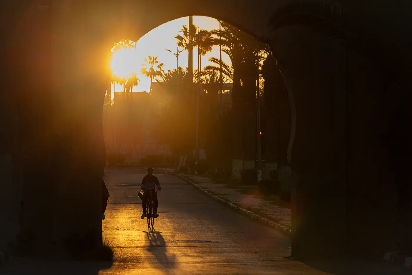 A cyclist entering the walls of Taroudant at sunrise